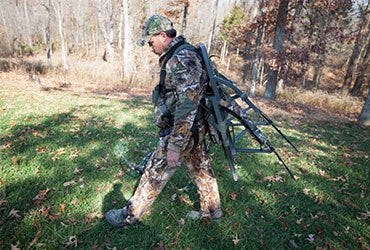 Man Carrying Tree Stand Through the Woods