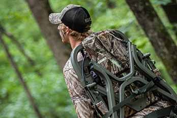 Hunter Walking Through the Woods with Treestand