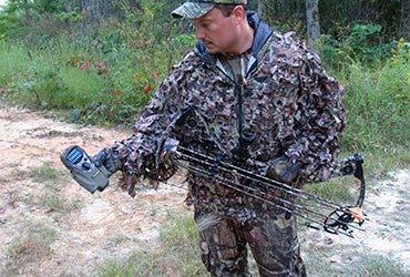 Bow Hunter in Woods Using ThermaCELL Unit 