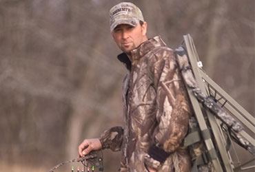 Man Walking Through the Woods Setting up Tree Stand 