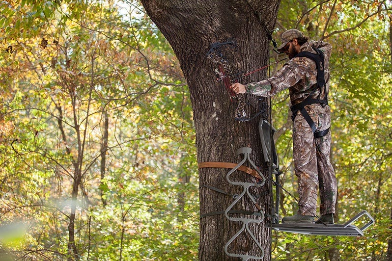 Hunter Using Hang-On Stand in the Woods 
