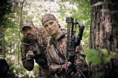 Two Hunters Walk Through the Woods with Bow 
