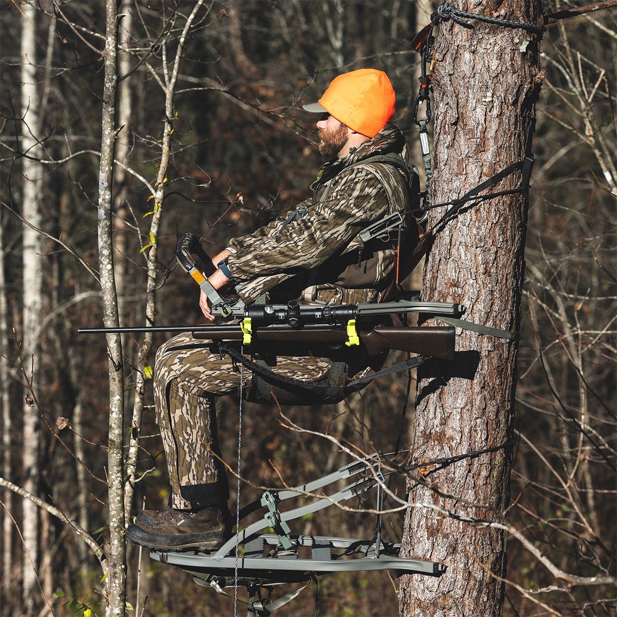 Man sitting in the Summit Dual Threat PRO SD climbing treestand in the Rifle Hunting position