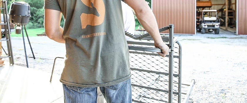 Man inspects his Summit treestand