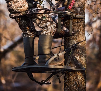 Hunter In Treestand Attached To Tree