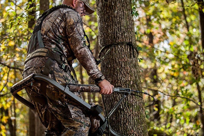 Hunter climbing tree with stand